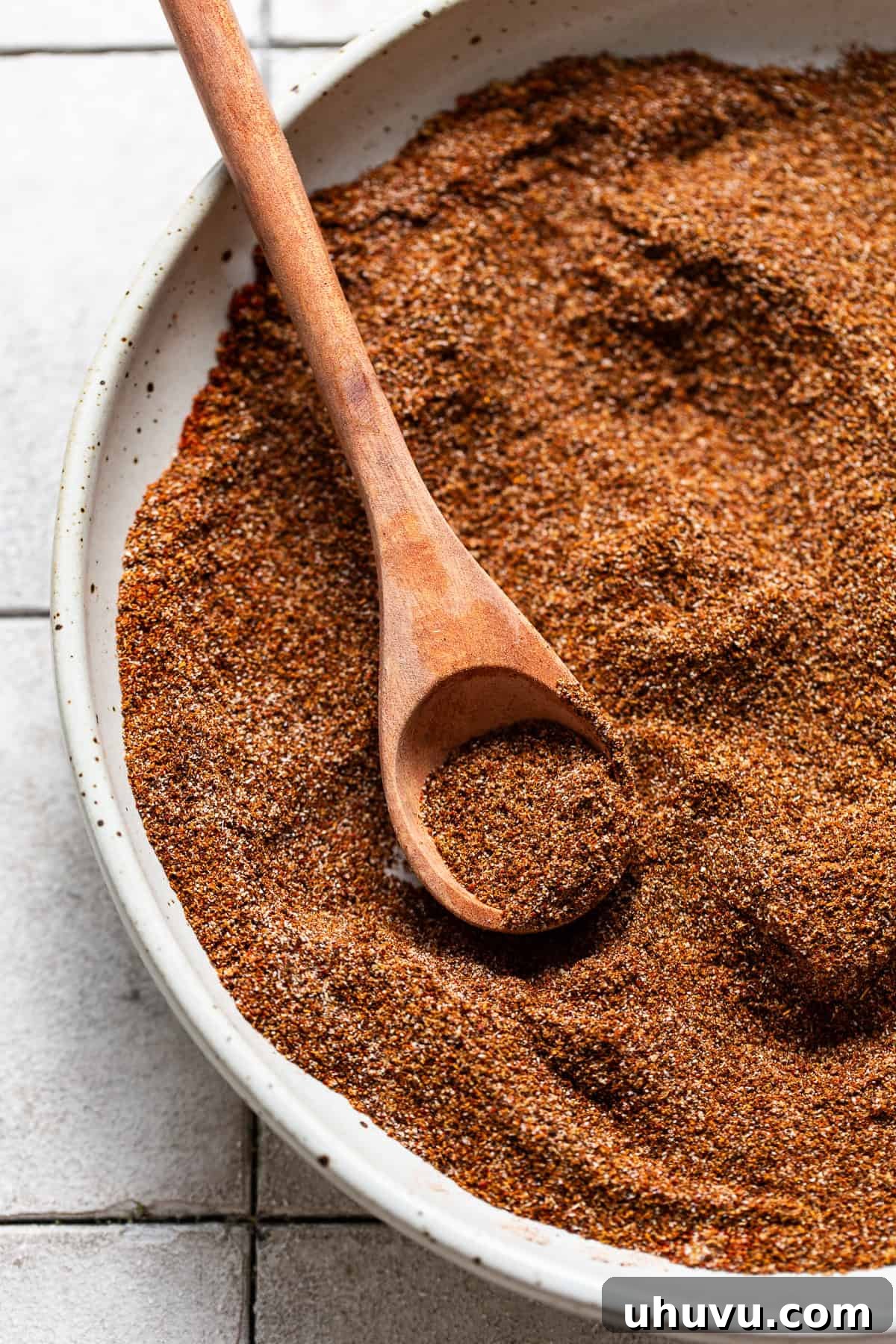 The homemade taco seasoning spices are thoroughly mixed in a large bowl, showcasing their vibrant color.