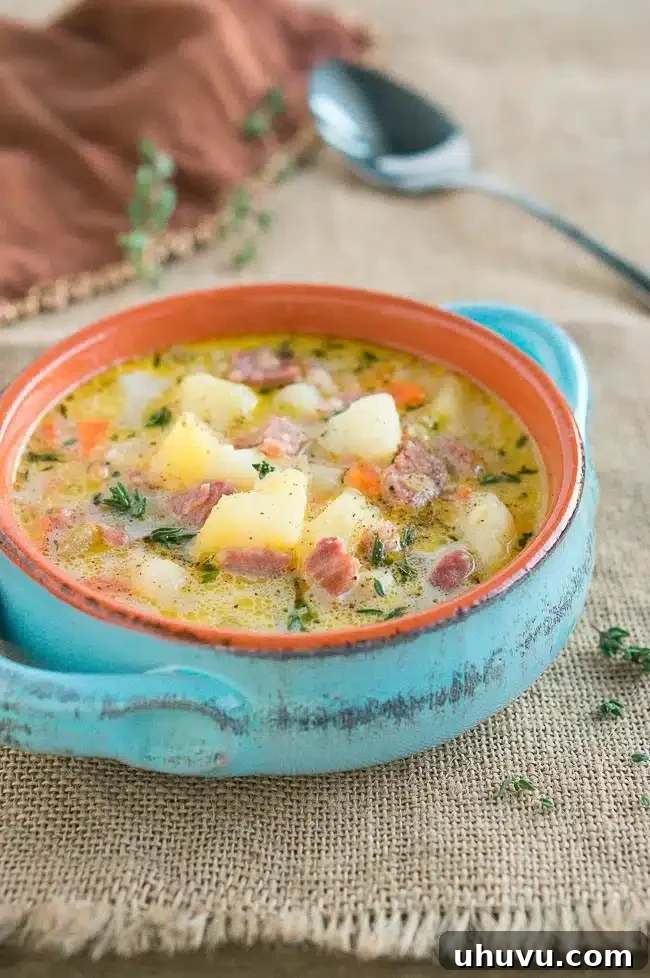 Comforting ham and potato soup served in a blue soup crock