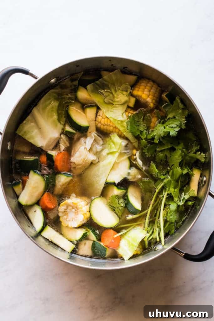 Heartwarming Beef and Vegetable Soup 6 Carrots, corn, potatoes, zucchini, cabbage, cilantro, and tomato paste being added to the simmering beef broth.