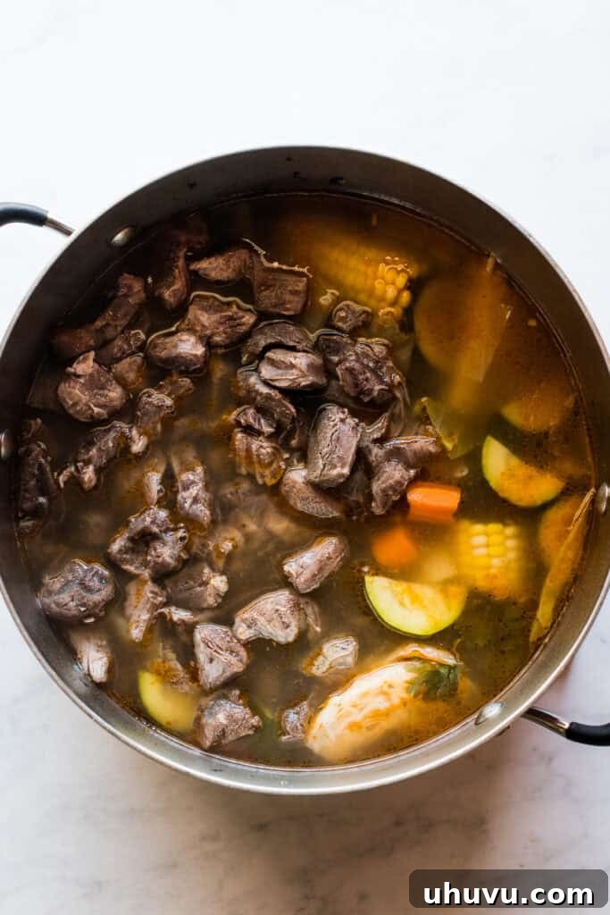 Heartwarming Beef and Vegetable Soup 7 Cooked beef shanks removed from the broth, with tender meat being cut off the bones.