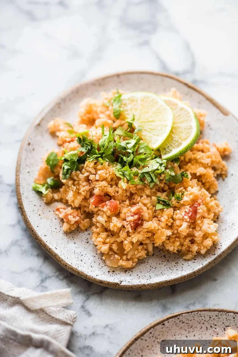Fiesta Cauliflower Rice 5 Mexican Cauliflower Rice served on a plate topped with chopped cilantro.