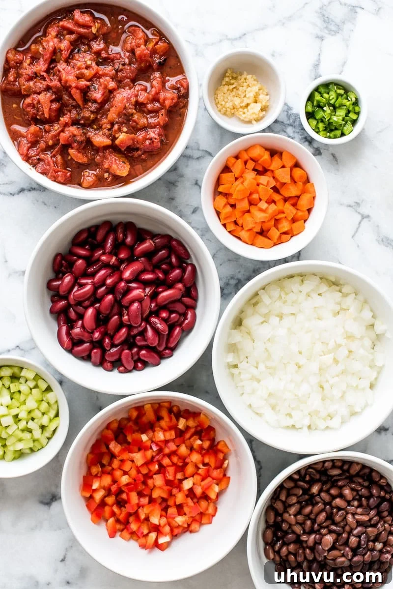 Fiery Plant-Based Chili 3 A bowl of thick, spicy vegetarian chili with toppings like shredded cheese and a side of cornbread.