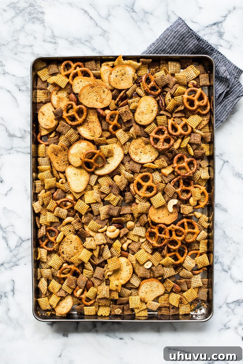 Addictive Fiery Chex Mix 4 A freshly baked batch of homemade Spicy Chex Mix cooling on a baking sheet, ready to be enjoyed.