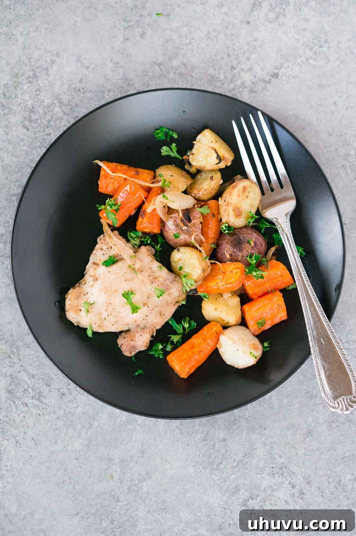 Effortless Eats: Healthy Sheet Pan Dinners 5 Baked Chicken and Potatoes on a black plate with a fork, a classic sheet pan dinner
