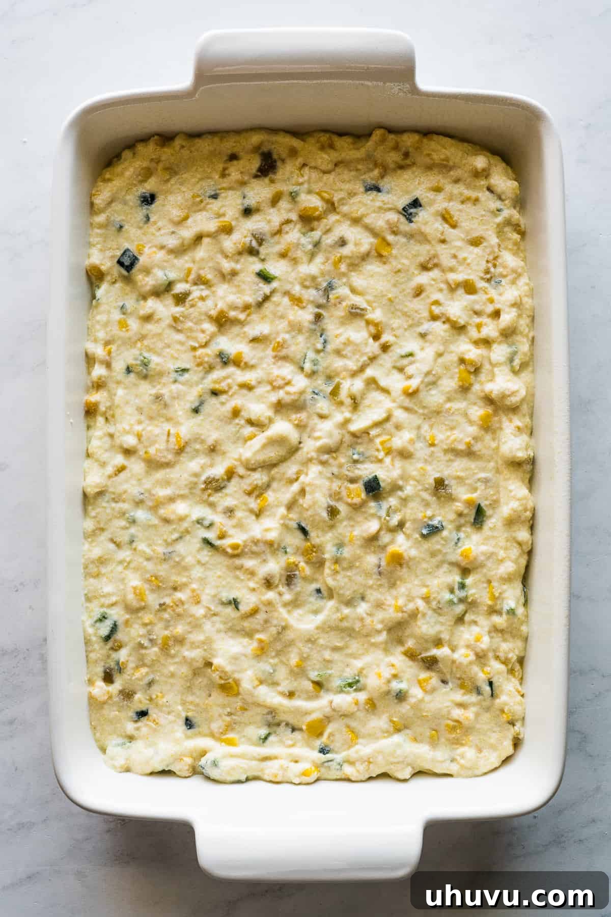 Zesty Green Chili Corn Bake 6 The green chili corn casserole batter is poured smoothly into a 9x13-inch baking dish, ready for the oven to transform it into a delicious side.