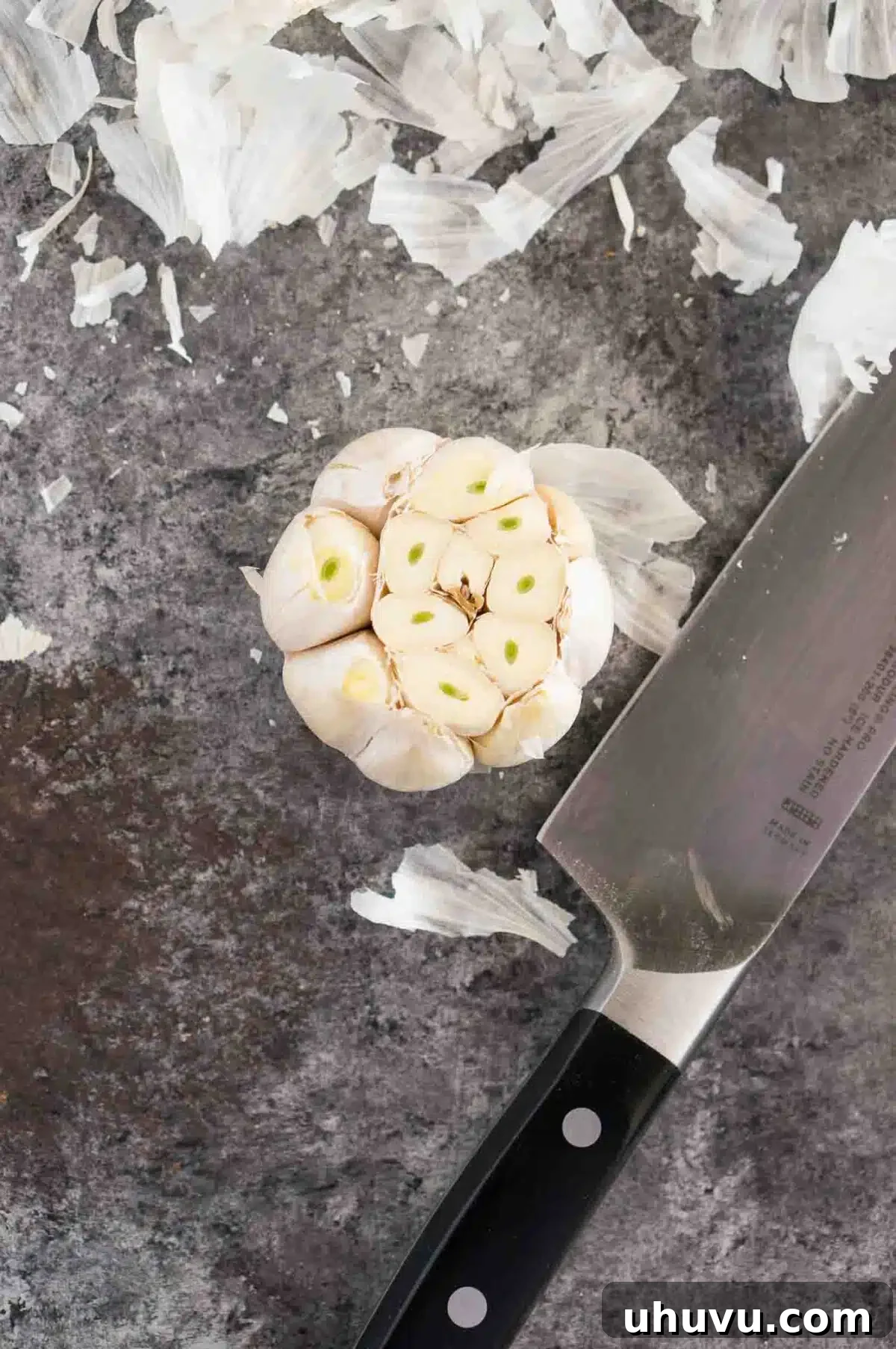 Preparation of garlic for roasting, showing the top cut off
