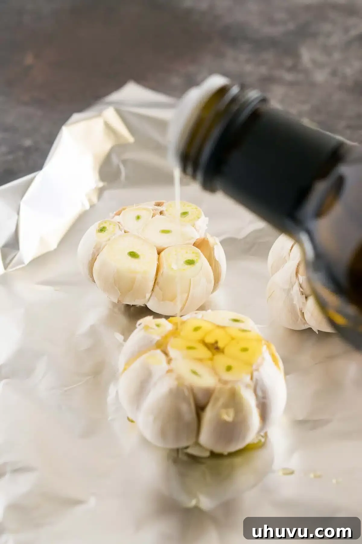 Garlic bulb drizzled with olive oil before roasting