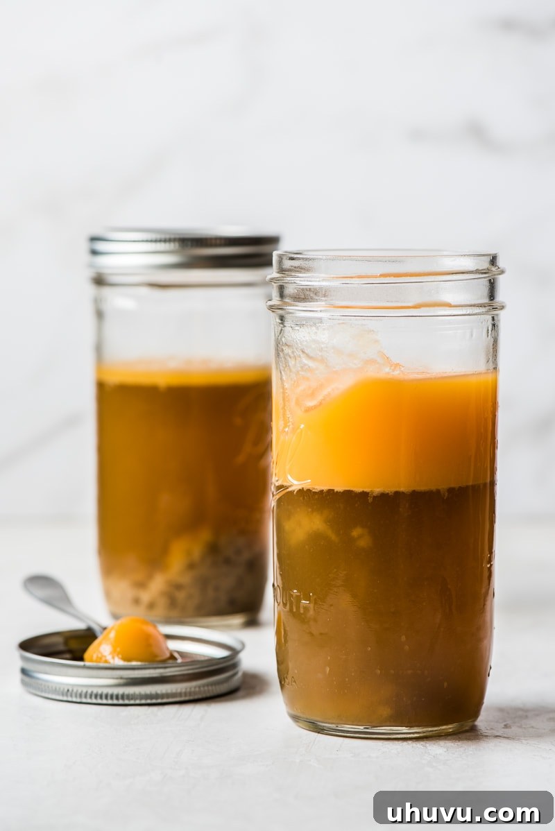 Perfect Turkey Gravy from Pan Drippings 3 Turkey gravy from drippings in a jar with the fat (solidified top layer) and liquid (darker bottom layer) visibly separated after chilling.