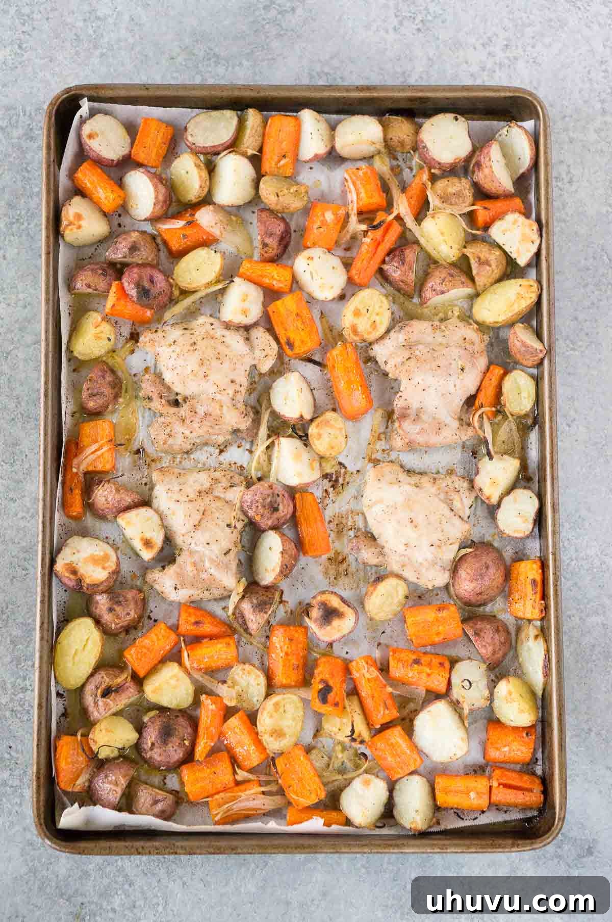 Golden Roasted Chicken and Crispy Potatoes 5 Baked chicken thighs and potatoes baking in an oven at 400 F.
