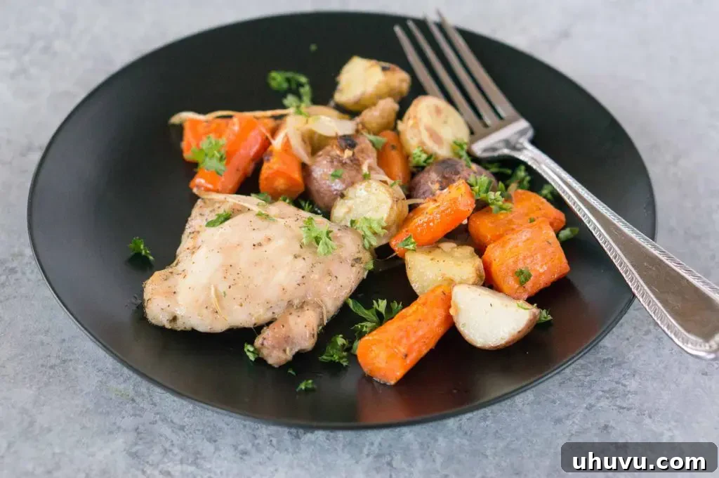 A serving of baked chicken, potatoes, and carrots on a plate, representing a healthy weeknight meal.