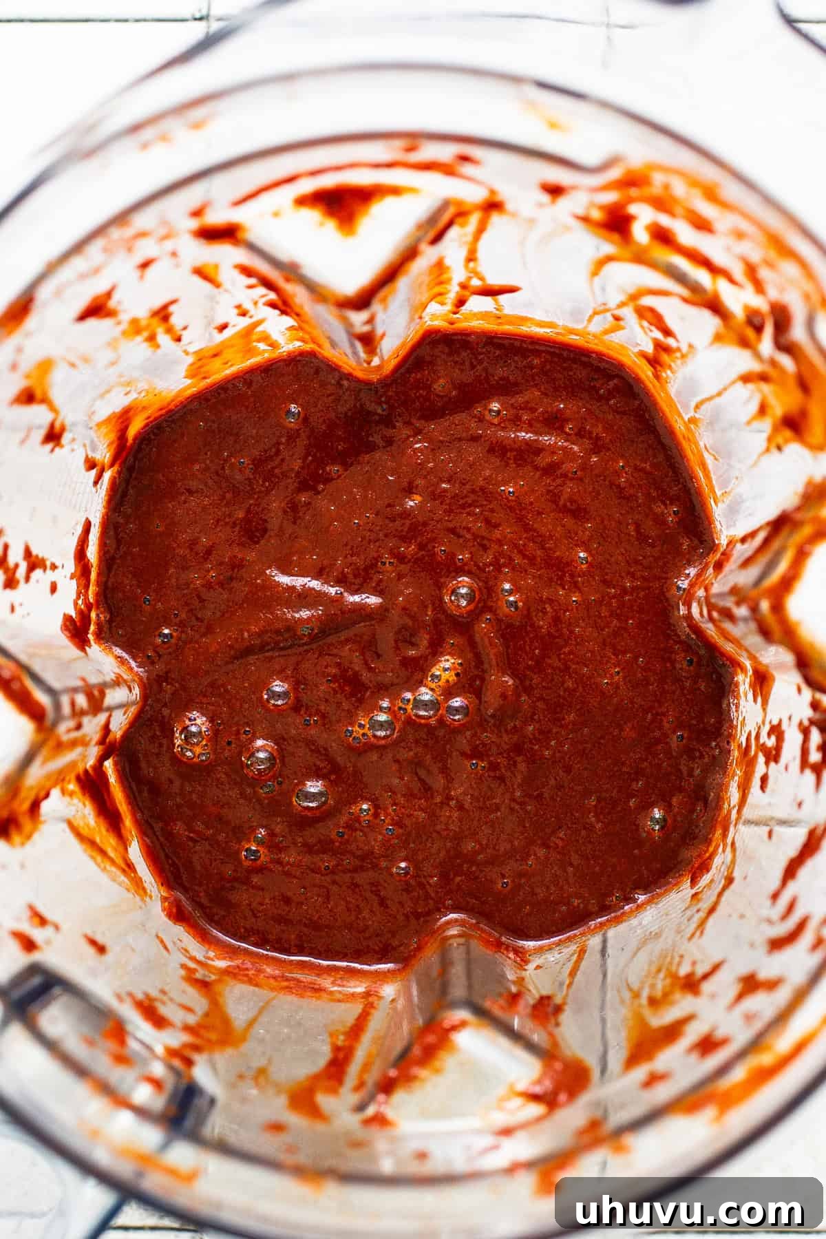 All the rehydrated dried chiles and other spices for the chile broth placed in a large blender, blended until the mixture is completely smooth and vibrant red.