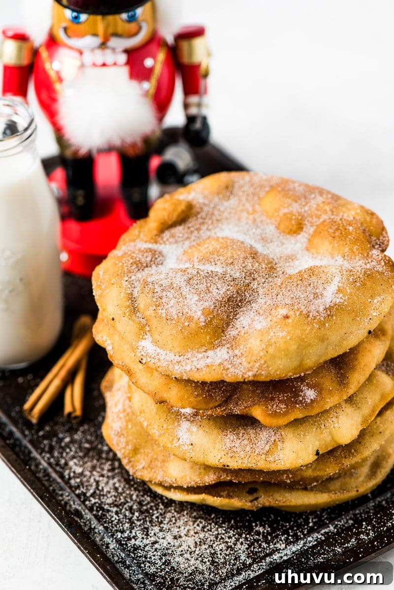 Crispy Cinnamon Sugar Buñuelos 2 Crispy Mexican Buñuelos covered in cinnamon sugar, a traditional holiday dessert.