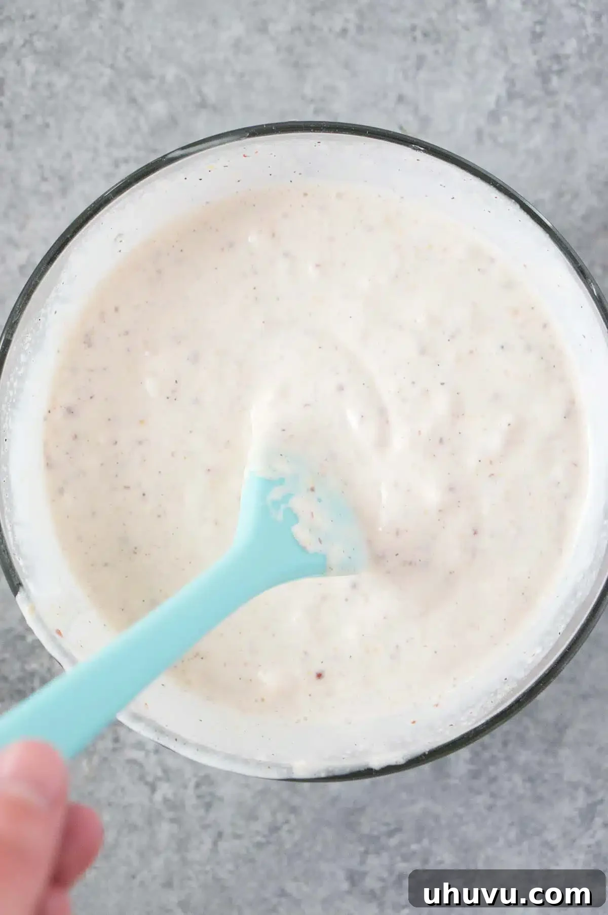 Smooth and creamy coleslaw dressing in a small mixing bowl, ready to be poured