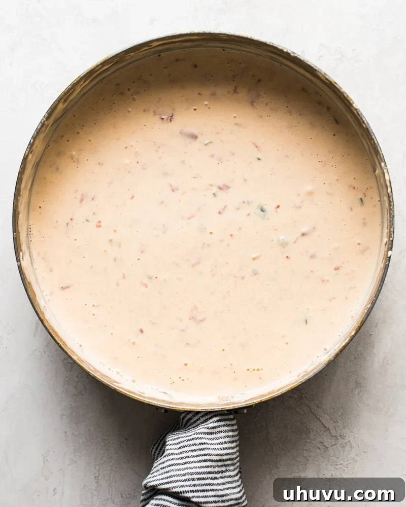 Quick Creamy Queso 6 A large saute pan filled with bubbling, melted Mexican queso dip, showcasing its rich and smooth consistency.