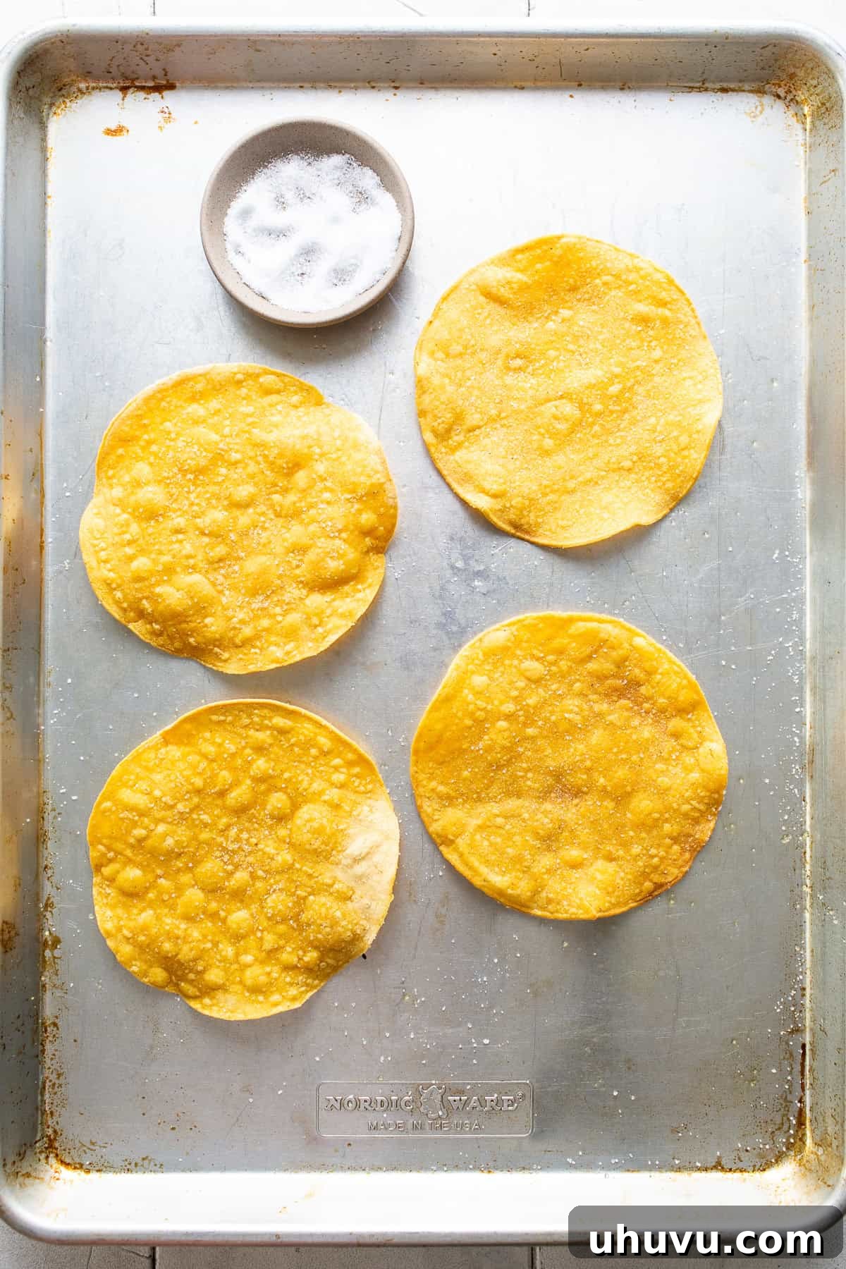 Golden Tostada Crisps 5 Baked corn tortillas on a baking sheet, golden brown and crispy, ready to be removed from the oven.