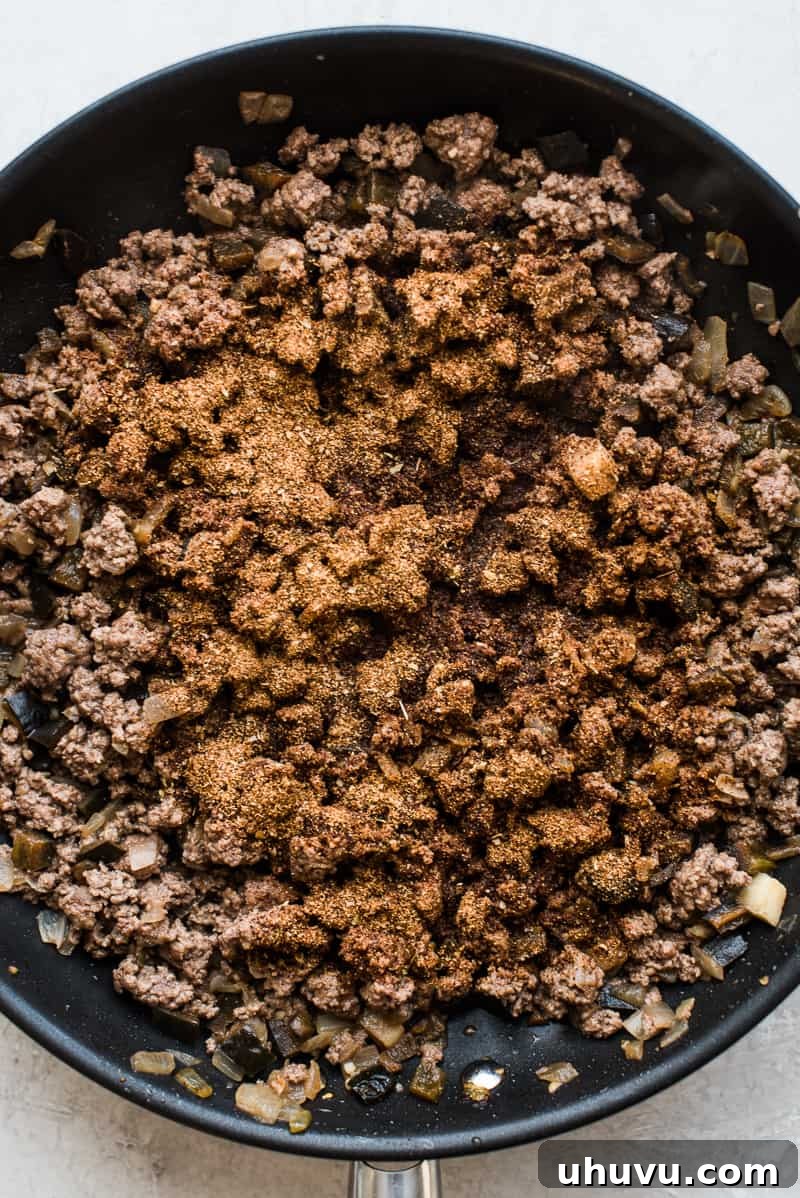 Effortless Taco Delight 4 Adding black beans, corn, and diced tomatoes to the taco meat.