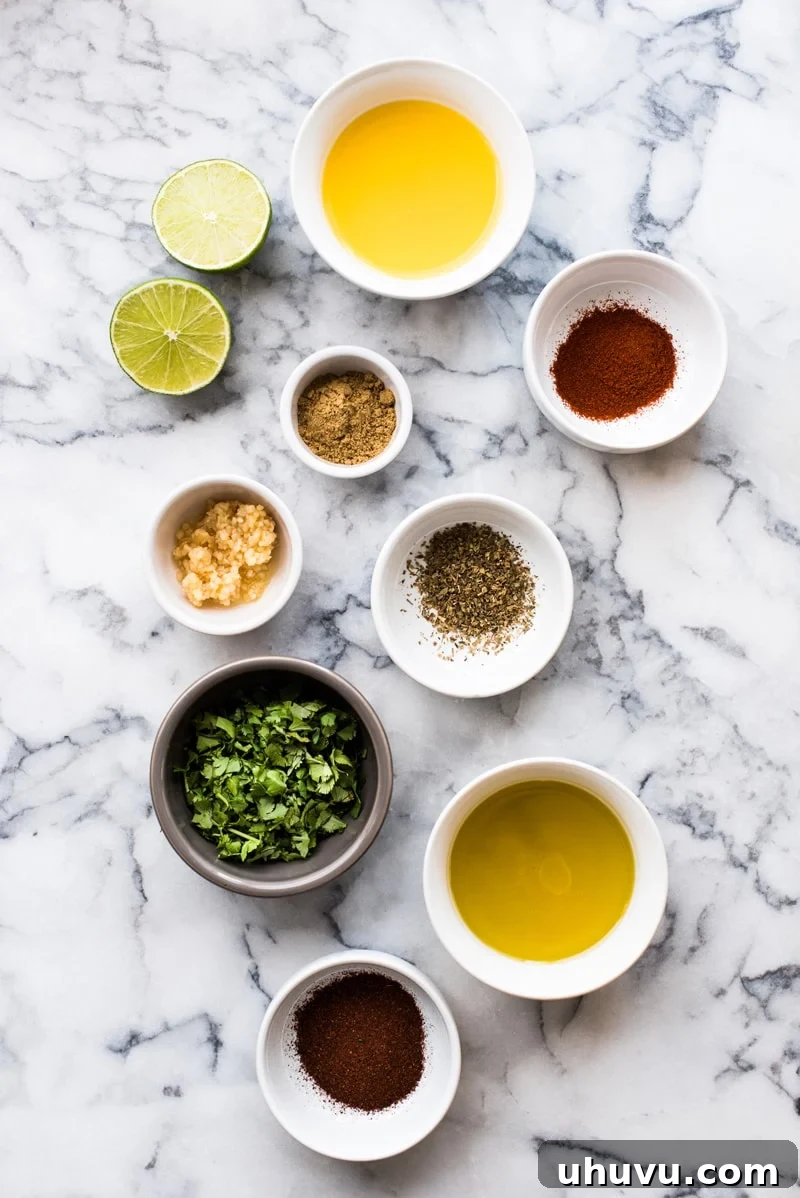 Steak fajita marinade ingredients on a table - olive oil, lime juice, orange juice, garlic, oregano, cumin, smoked paprika and cilantro.