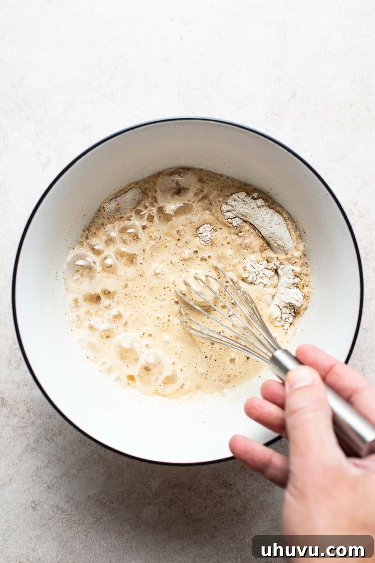Golden Crispy Baja Fish Tacos 7 Flour, seasonings, and beer being whisked together in a bowl to create the perfect crispy batter for Baja Fish Tacos.