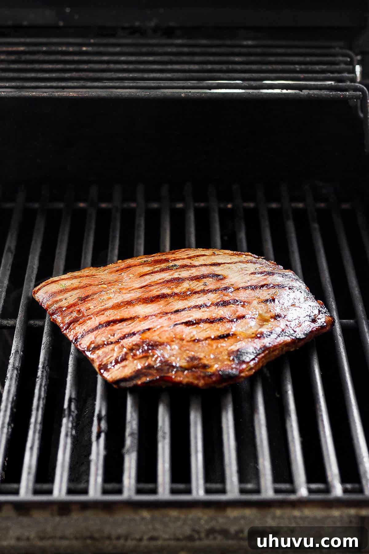 Flank steak placed on a grill until cooked through. 