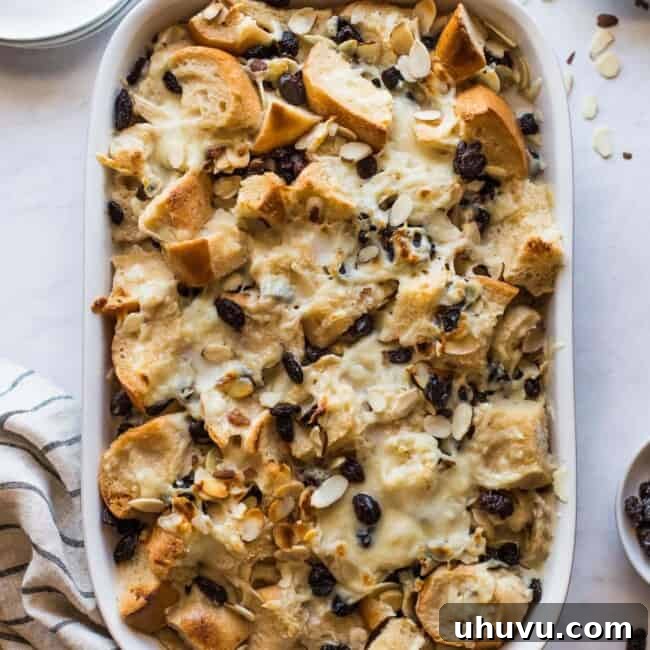 Capirotada (or Mexican Bread Pudding) in a baking dish topped with raisins and cheese.