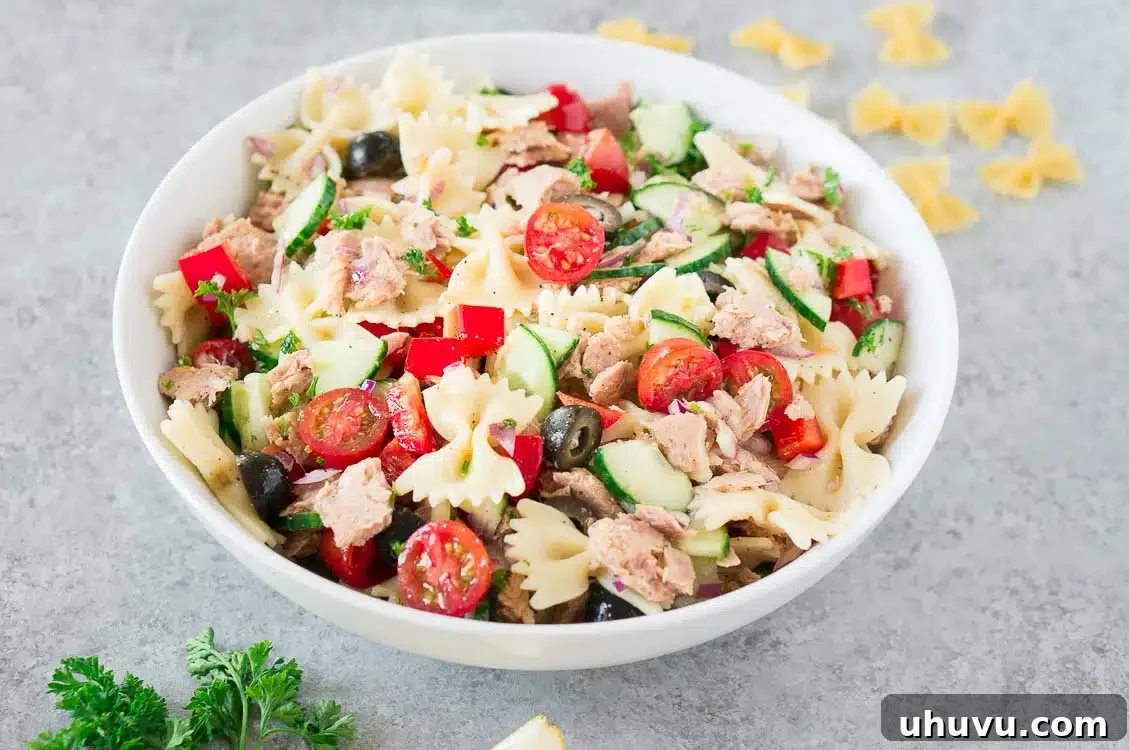 Close-up of a vibrant pasta with tuna, cherry tomatoes, and fresh herbs