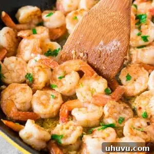 easy shrimp scampi recipe in a skillet with a wooden spoon