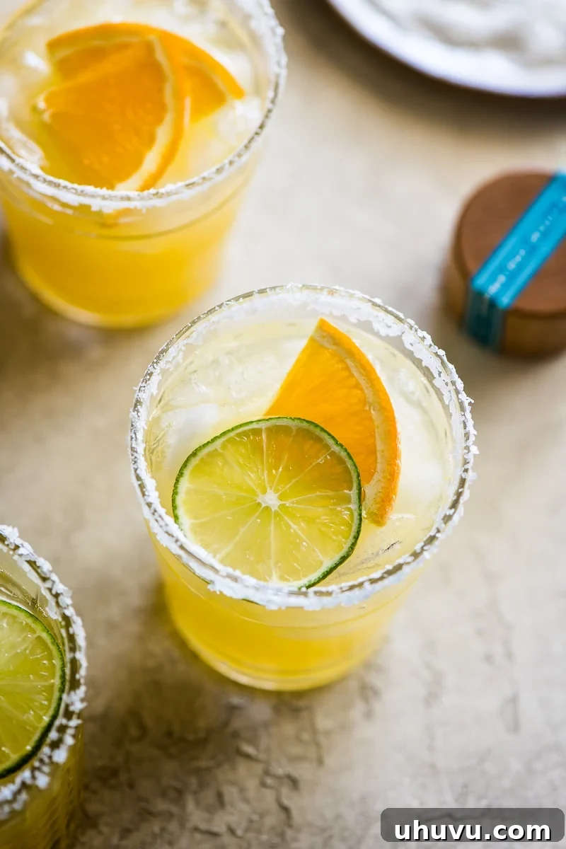 Cocktail glass rimmed with salt and filled with a vibrant skinny margarita.