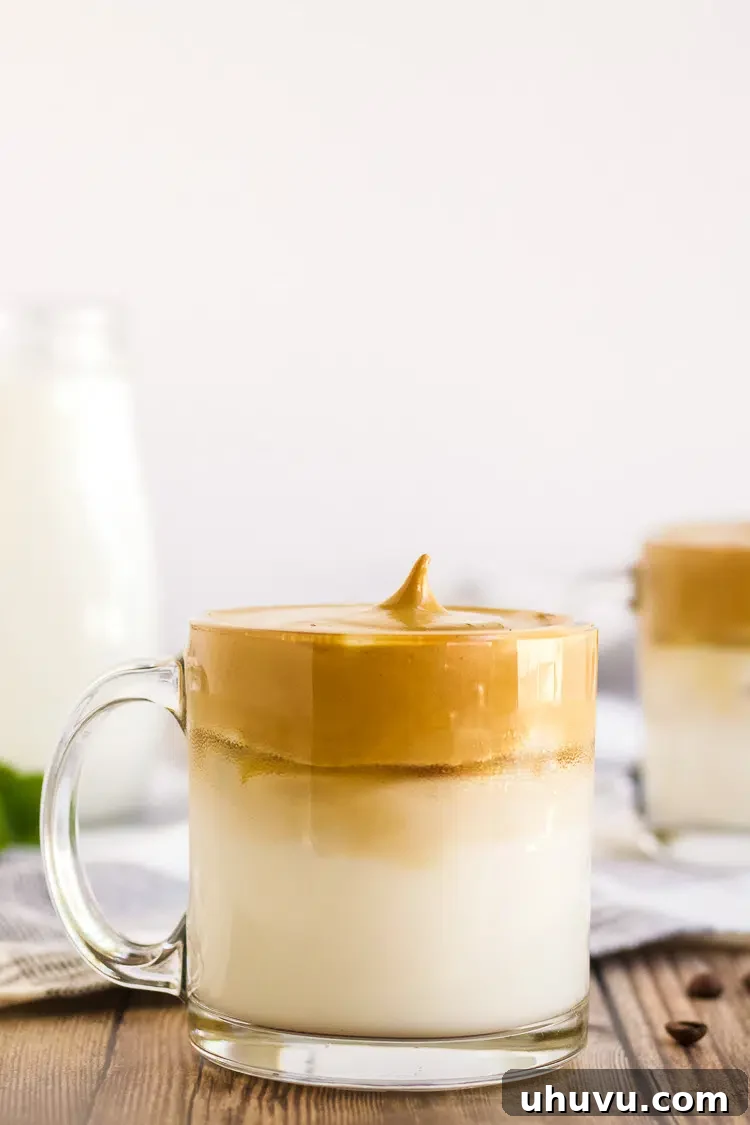 Mug of perfectly whipped Dalgona coffee foam floating on milk