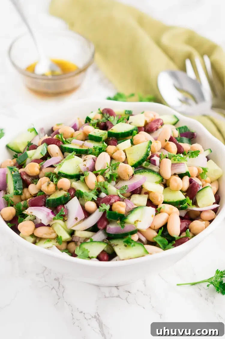 A vibrant three bean salad in a white bowl, ready to serve.