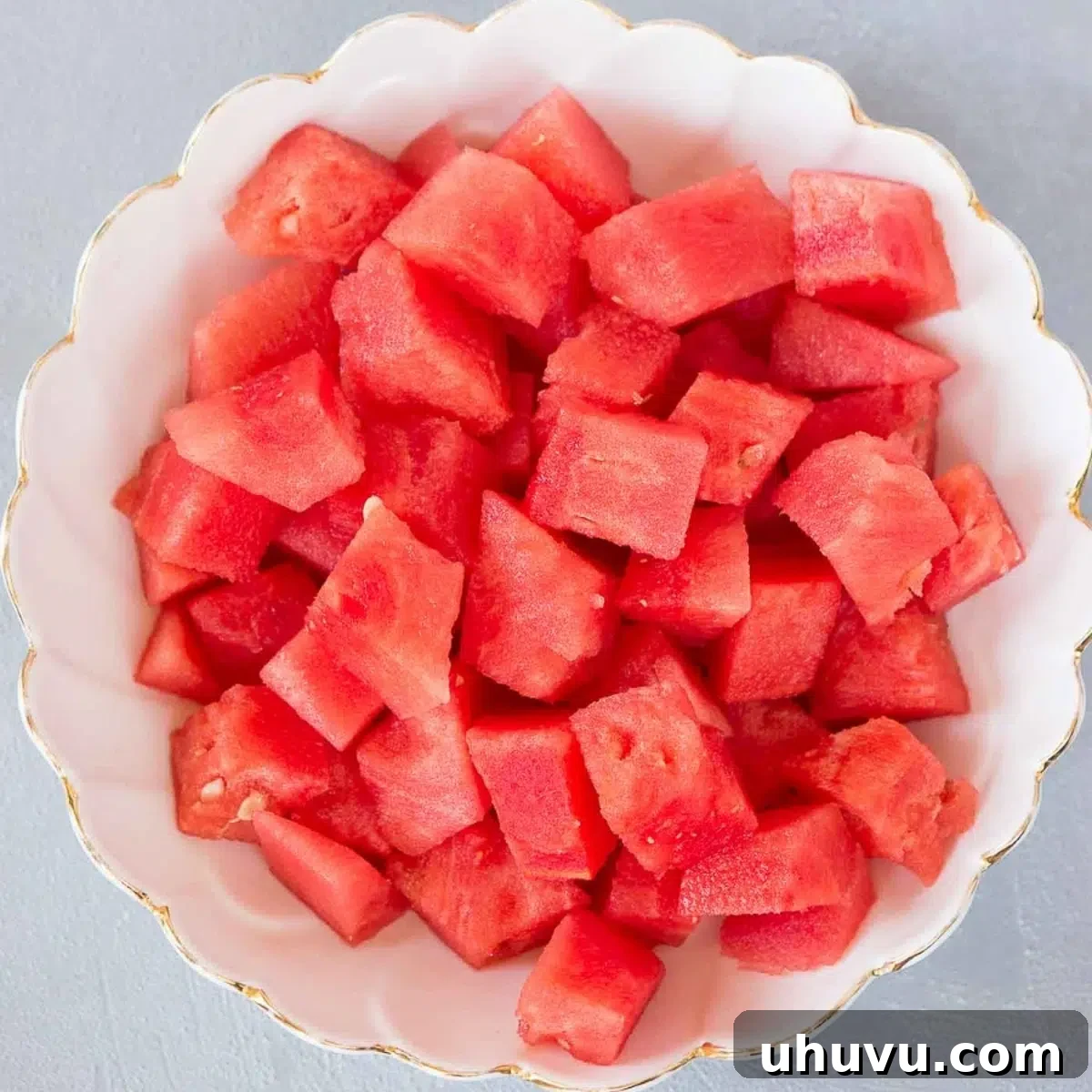 A bowl filled with perfectly cut watermelon cubes, ready to serve.