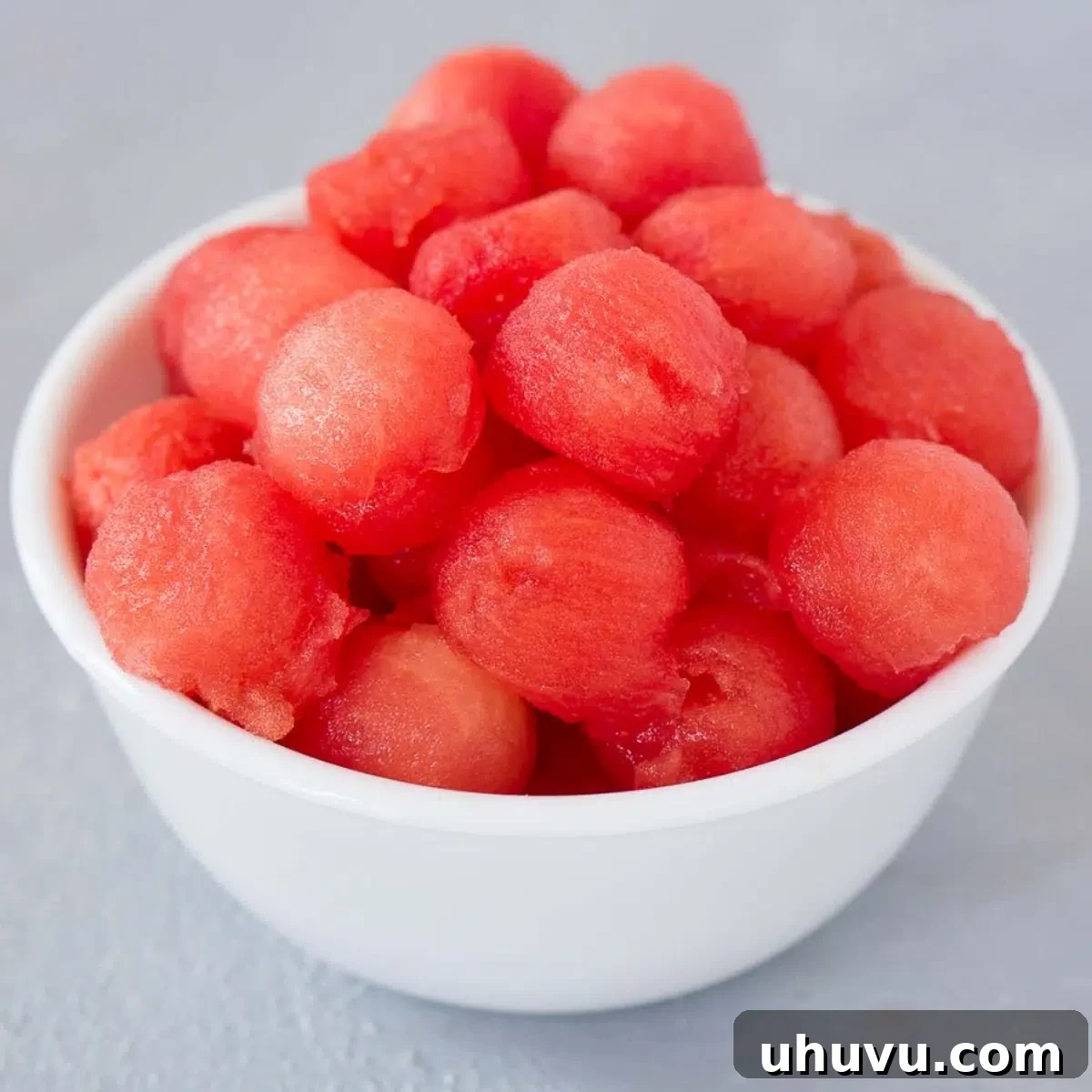 A bowl brimming with perfectly scooped watermelon balls, ready for a fancy fruit salad.