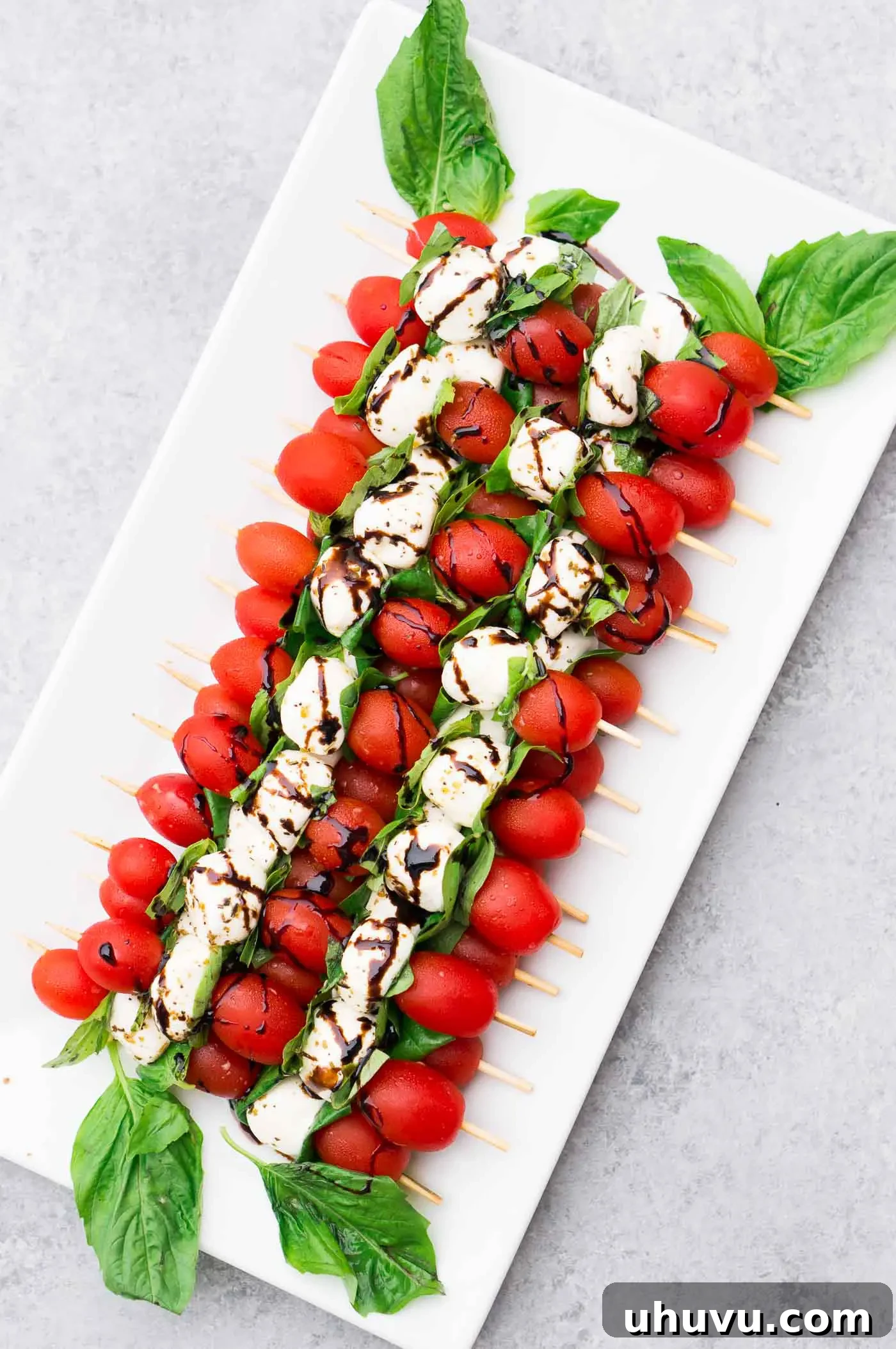 Delicious Caprese Skewers with Balsamic Glaze on a white platter, ready to serve