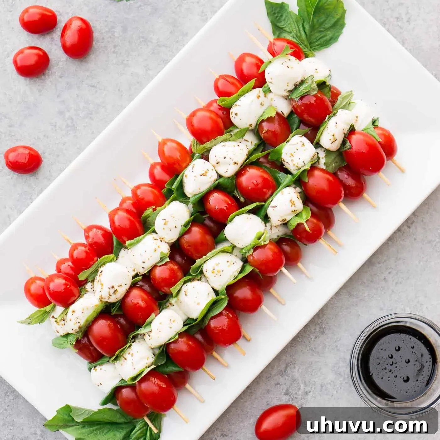 Platter of neatly arranged Caprese skewers, ready for the final balsamic drizzle