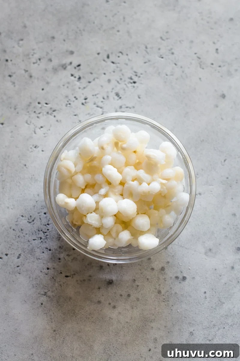 White hominy kernels in a small glass bowl, ready for cooking.