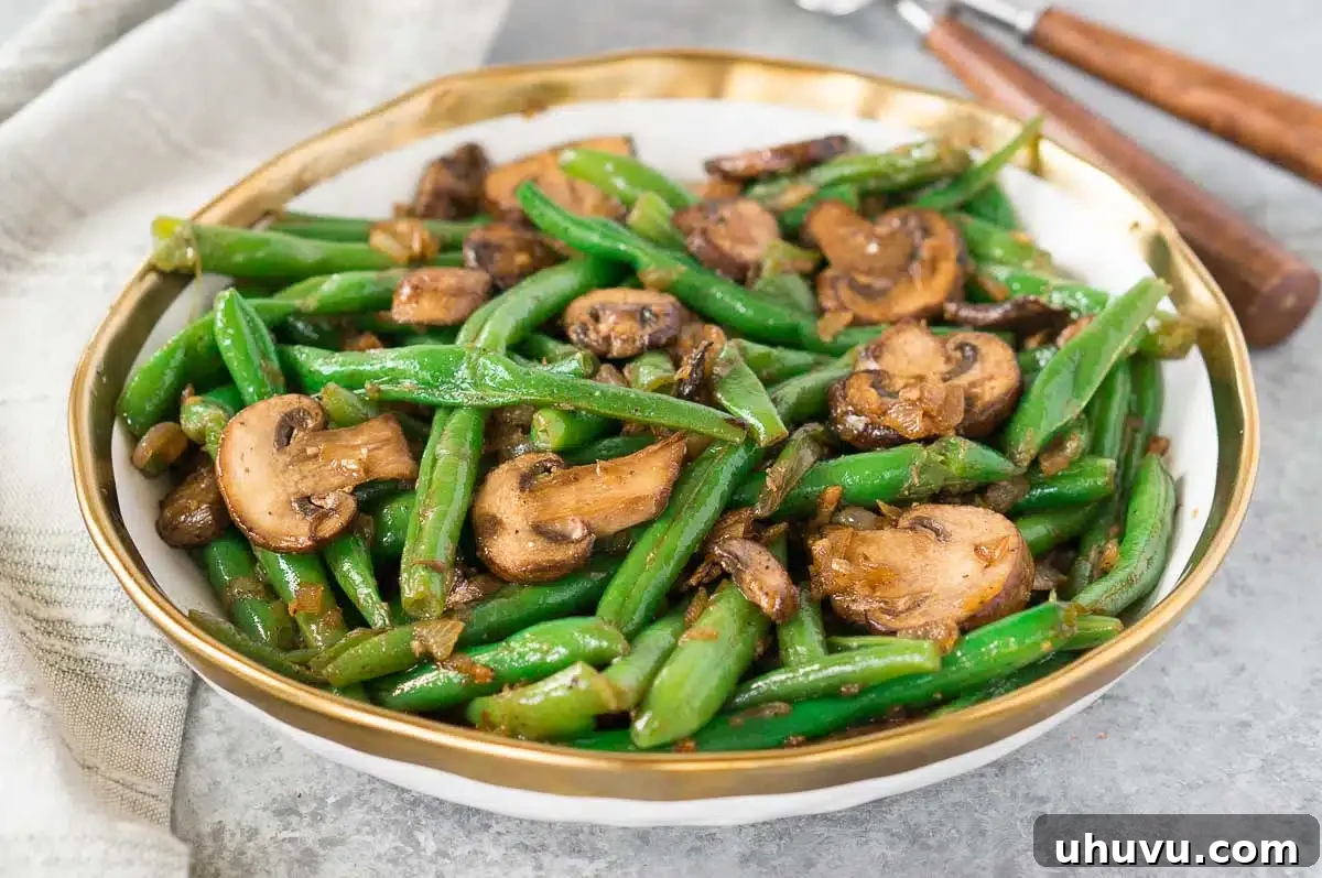 healthy green beans and mushrooms on a board with fork and napkin in background