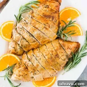roast turkey breast on a platter with rosemary and oranges