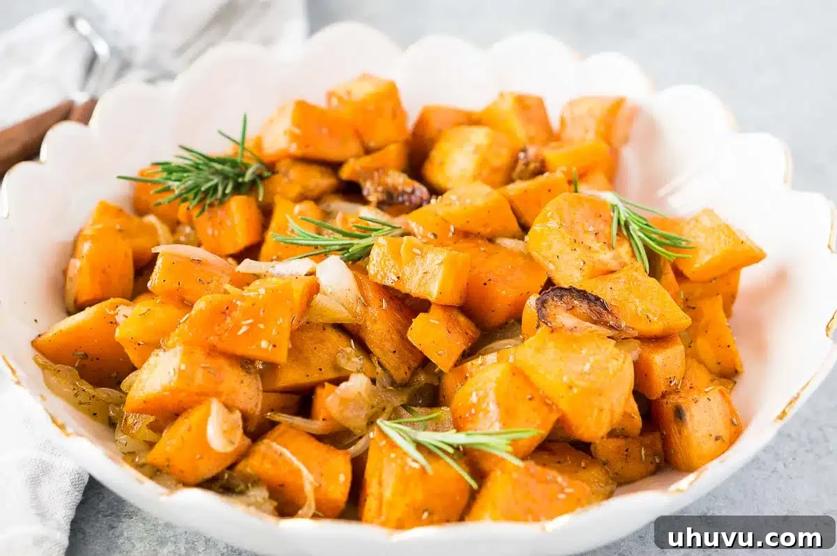 Close-up of a white bowl filled with Whole30 compliant roasted sweet potatoes and onions, perfect for Thanksgiving