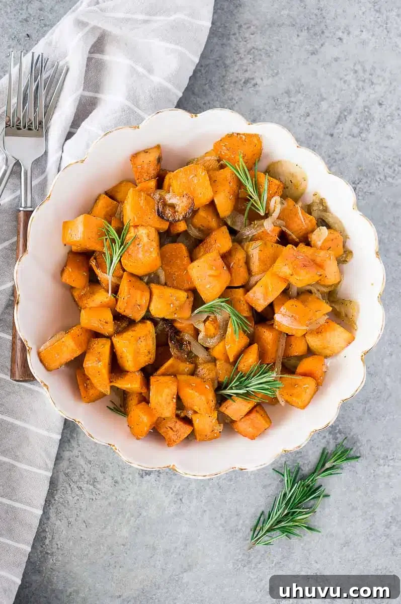 Sweet potatoes and onions with fresh rosemary in a bowl, ready to be served