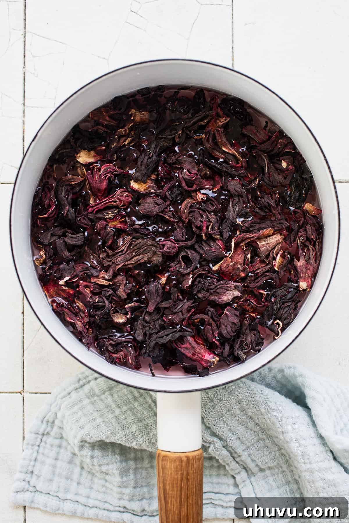 Ruby Hibiscus Refresher 4 Dried hibiscus flowers simmering in a pot of water on the stove.
