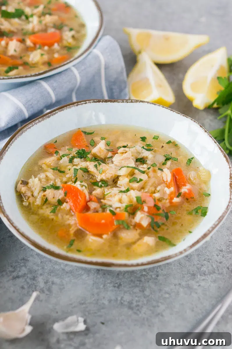 Close up image of a steaming bowl of homemade soup with leftover turkey and rice, garnished with fresh herbs, ready to be enjoyed