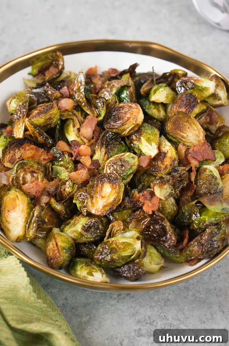 Close-up of golden and crispy roasted Brussels sprouts with bacon bits on a baking sheet