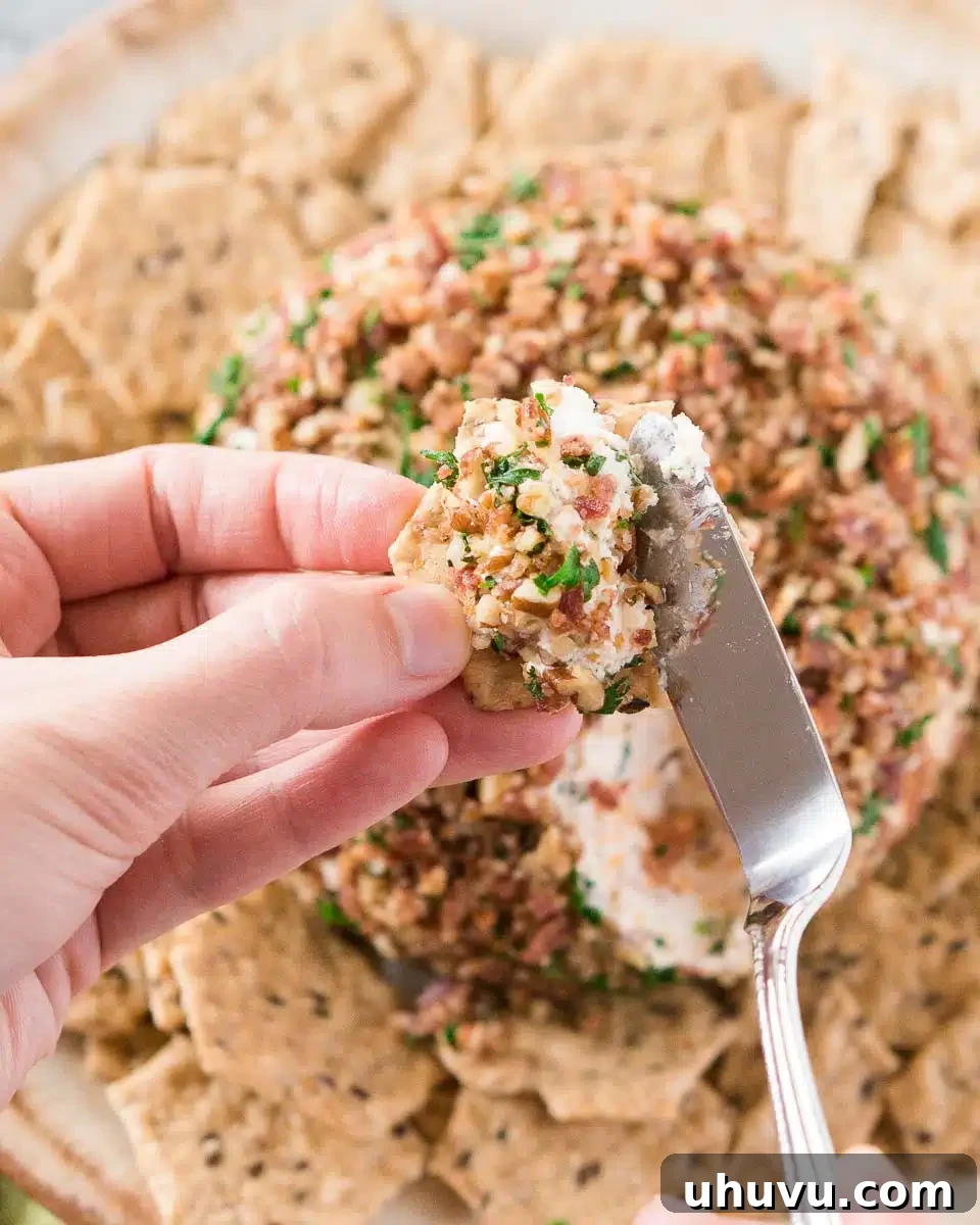 spreading ranch bacon cheese ball on a cracker