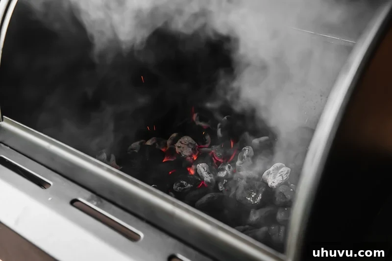 Lit charcoal evenly spread across the bottom of a charcoal grill, ready for direct heat cooking.