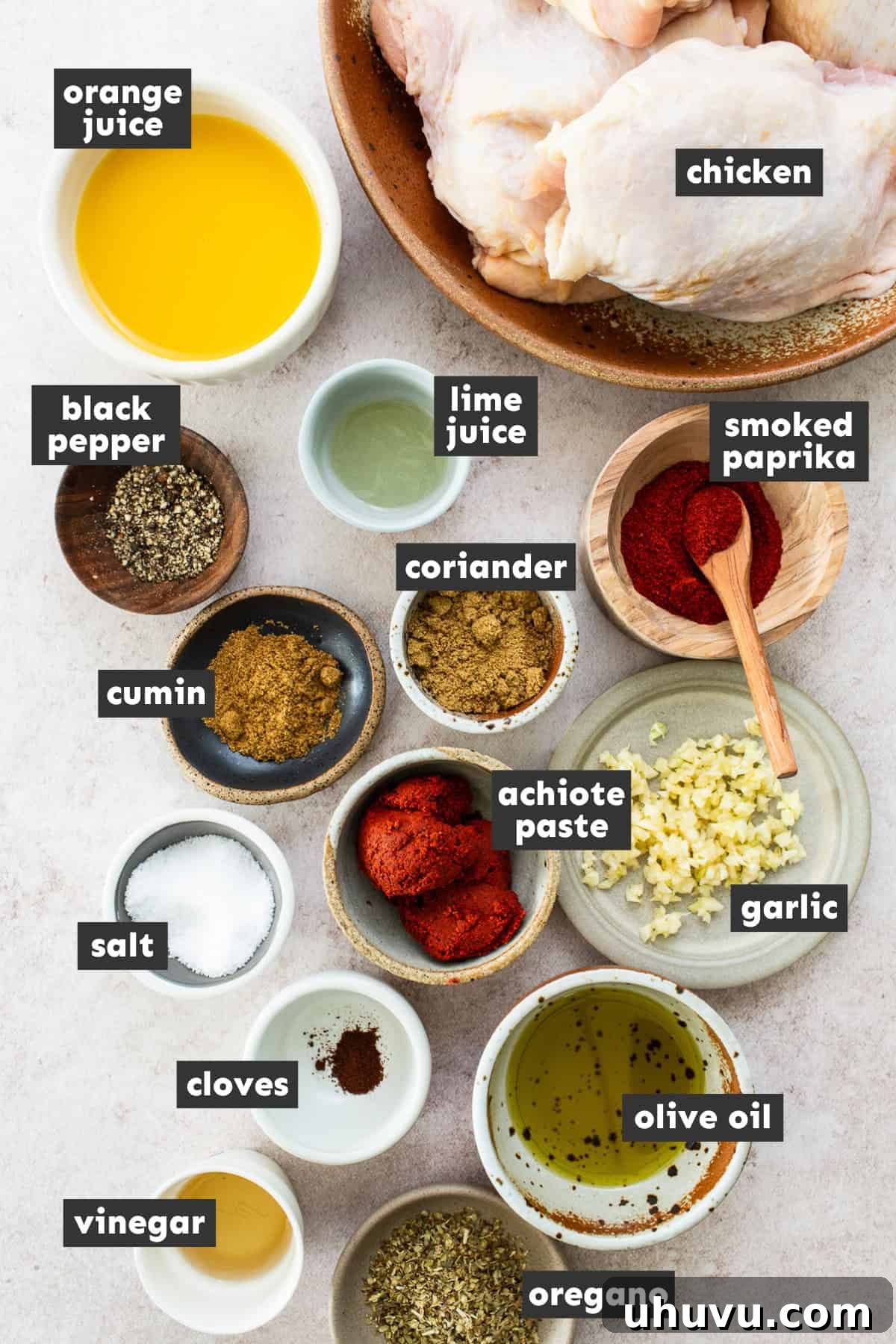 Flavorful Roasted Chicken 3 Fresh ingredients laid out on a wooden table, including chicken, garlic, oranges, limes, and various spices for Pollo Asado.