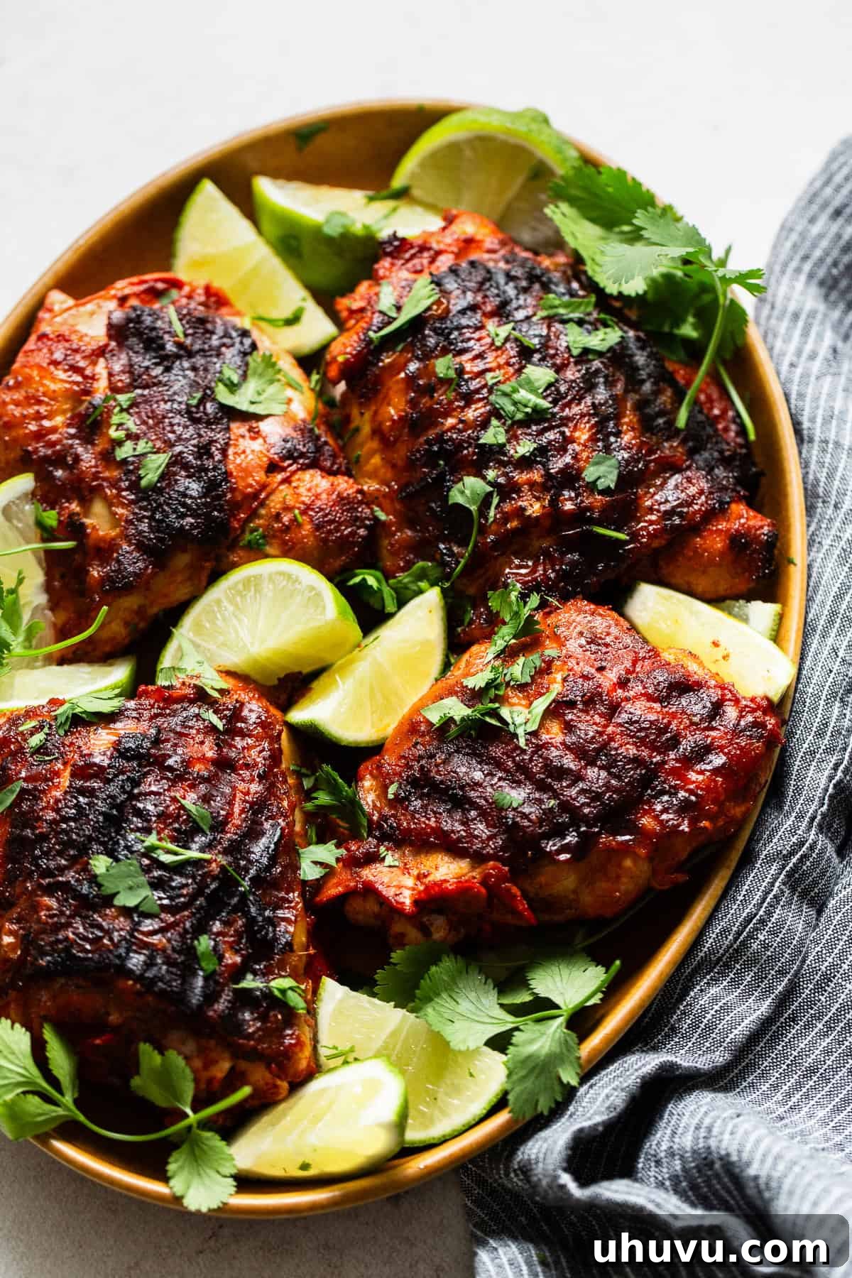 Flavorful Roasted Chicken 6 Marinated pollo asado artfully arranged on a serving plate with fresh lime wedges, ready to be enjoyed.