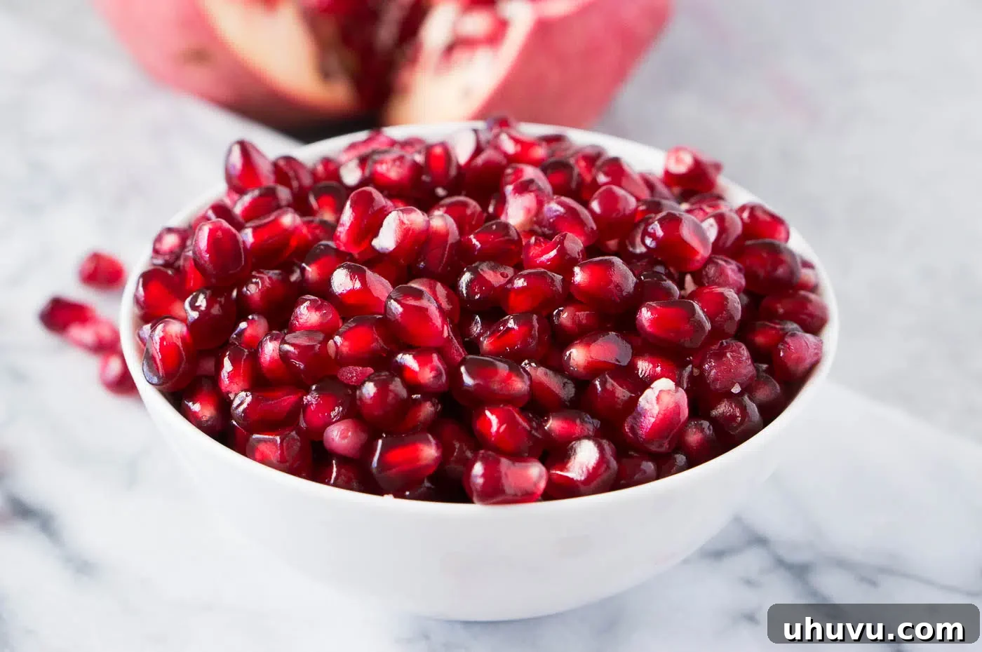 Close-up image of vibrant, deseeded pomegranate arils, sparkling and ready to eat.