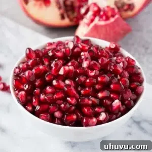 Pomegranate seeds in a white bowl, ready for recipe use