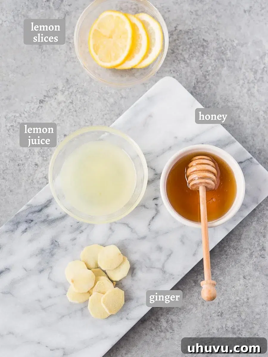 Arrangement of fresh ingredients for lemon ginger tea, including sliced ginger root, whole lemons, and a jar of honey.