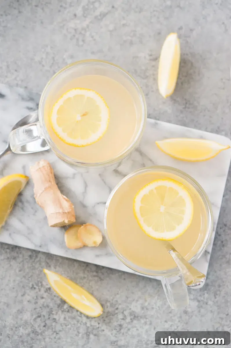 Two glass mugs of lemon ginger tea with lemon slices, ready to be enjoyed.