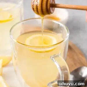 pouring honey in lemon tea